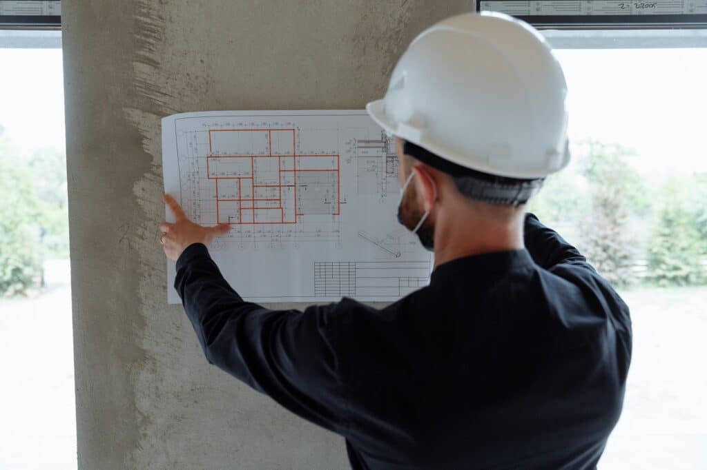 A general contractor at a construction site reviewing plans.
