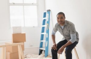 Black man sitting in room under renovation
