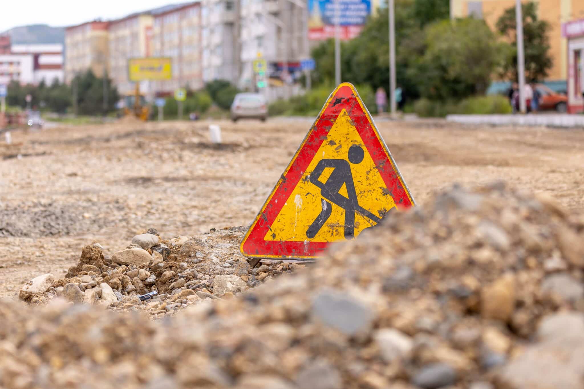 Sign with a person using a shovel indicating a construction site.