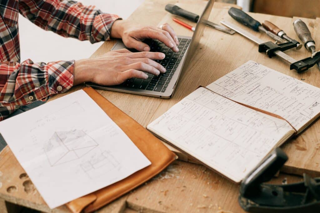 Construction contractor using a laptop on his workbench