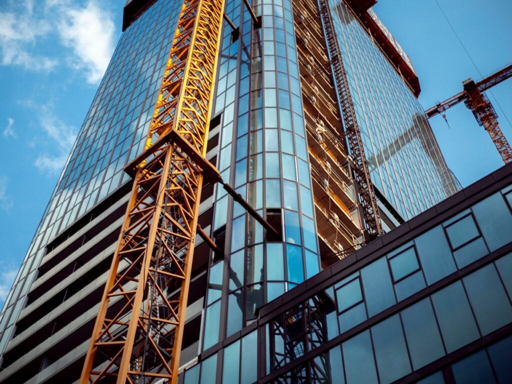 A yellow crane being used to construction a commercial office building