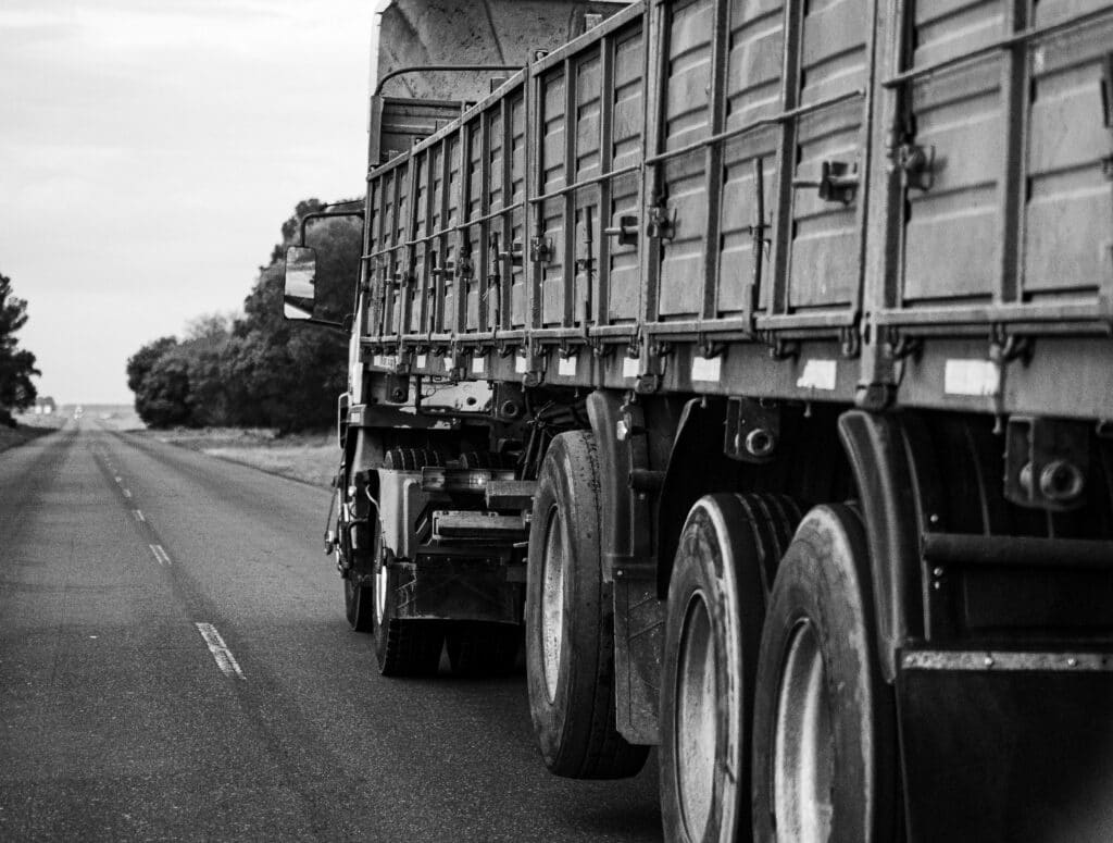 Large truck carrying materials to a jobsite in black and white.