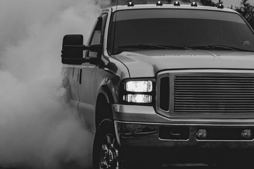 Pickup truck kicking up dust in black and white